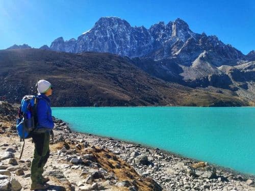 A trekker standing at Gokyo Ri lake and enjoying panoramic views