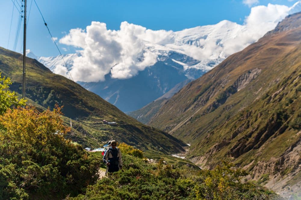 Trekker walking through a mountain valley