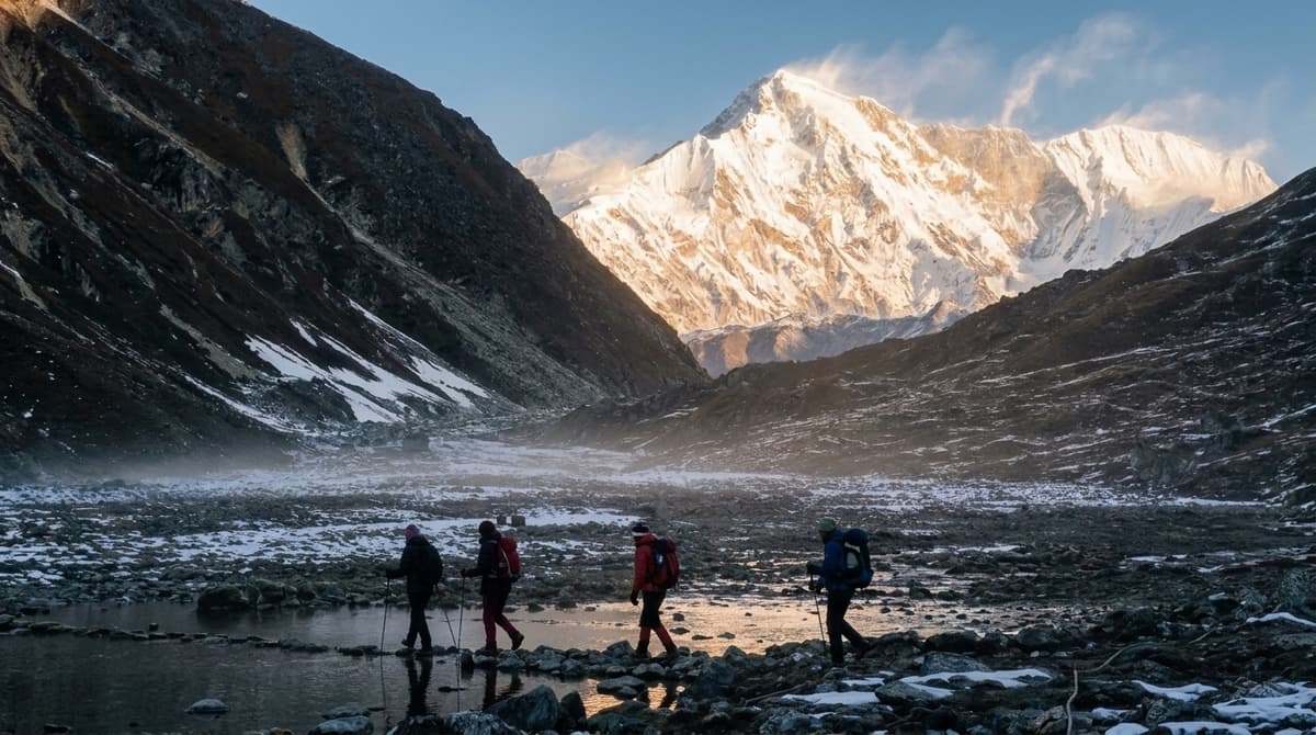 Trekkers walking through a Himalayan valley beneath snow-covered mountains in Nepal