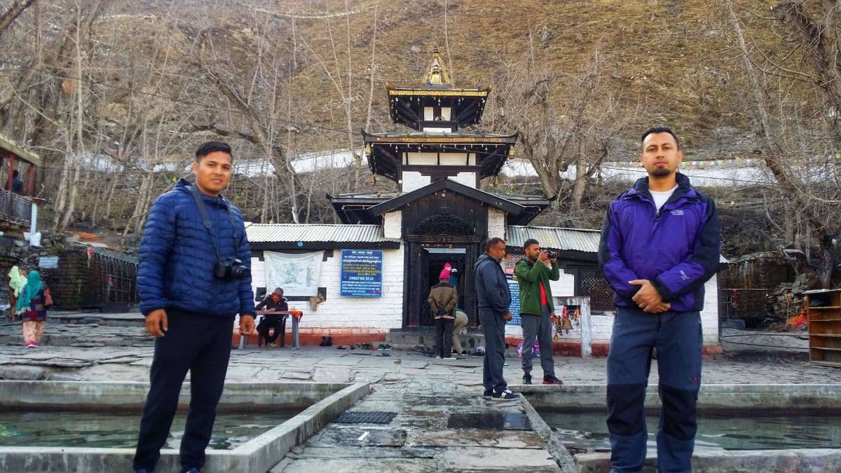 trekkers taking photo infront of muktinath temple