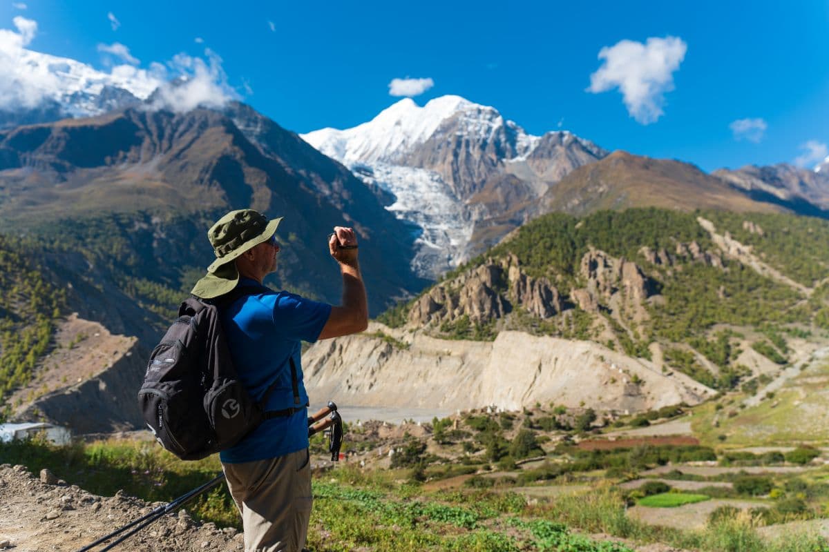 trekker clicking pictures of mountains in nepal