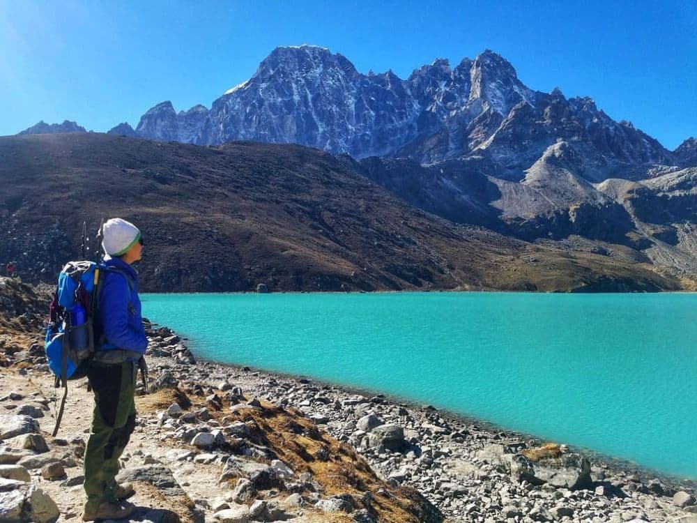 A trekker standing at Gokyo Ri enjoying panoramic views